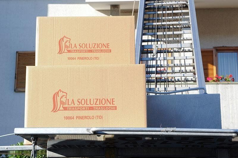 Due scatole di cartone impilate su una piattaforma con un sollevatore meccanico.