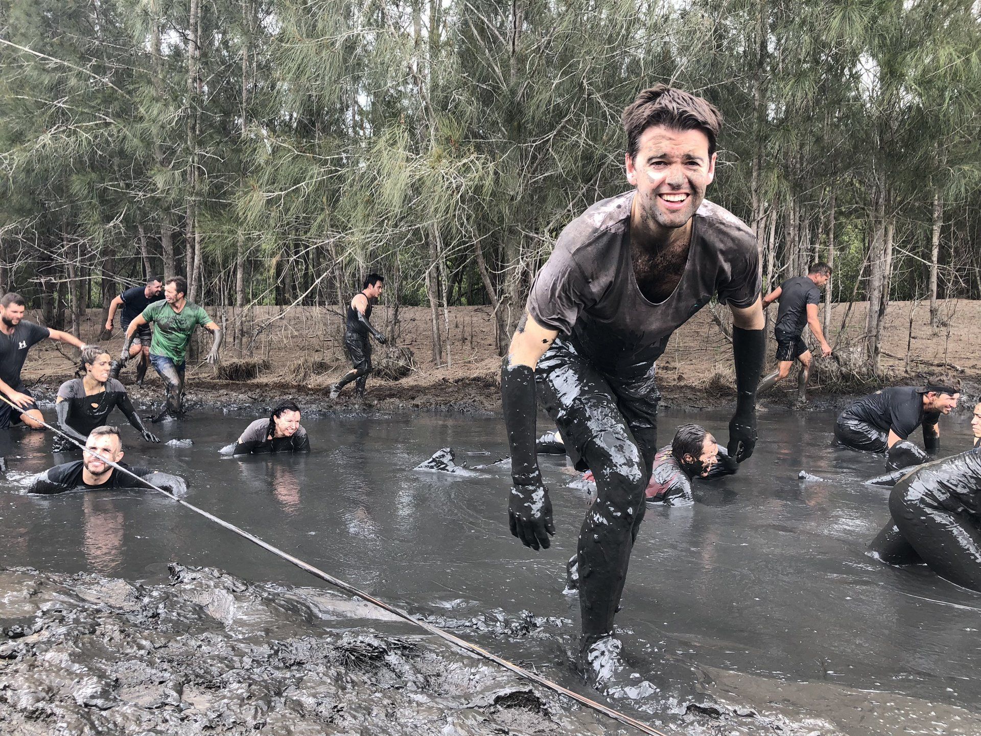 A group of people are standing in a muddy pond.