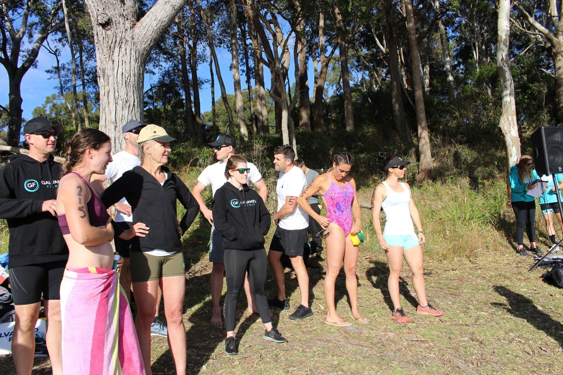 A group of people are standing in a field with trees in the background.