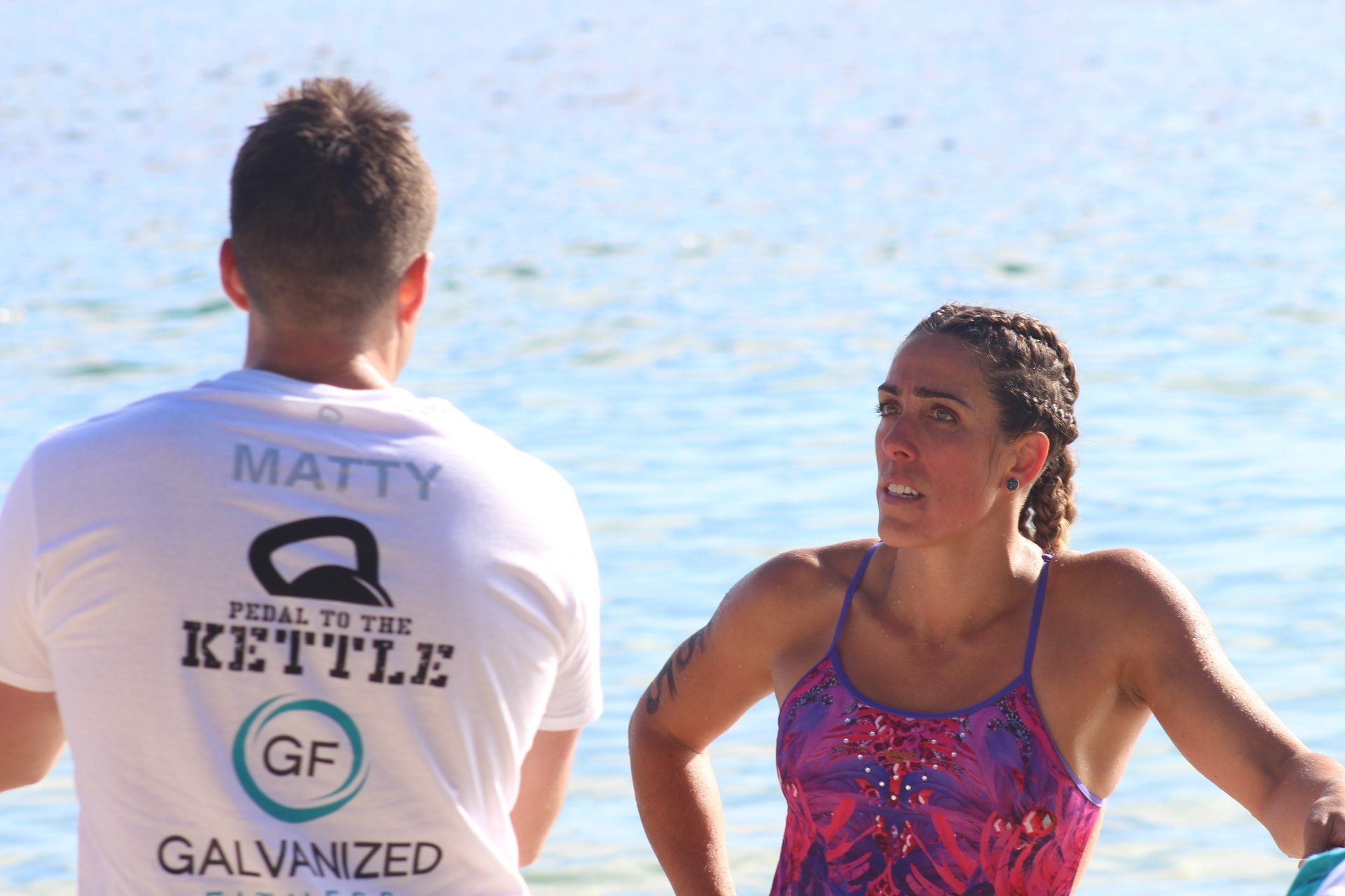 A man and a woman are standing next to each other on the beach.