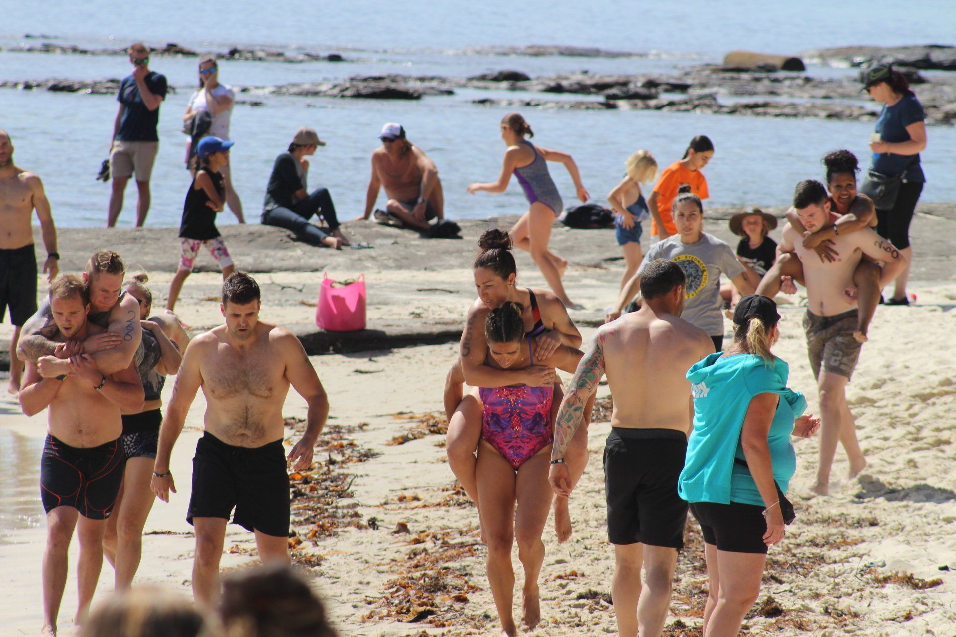 A group of people are walking on a beach.