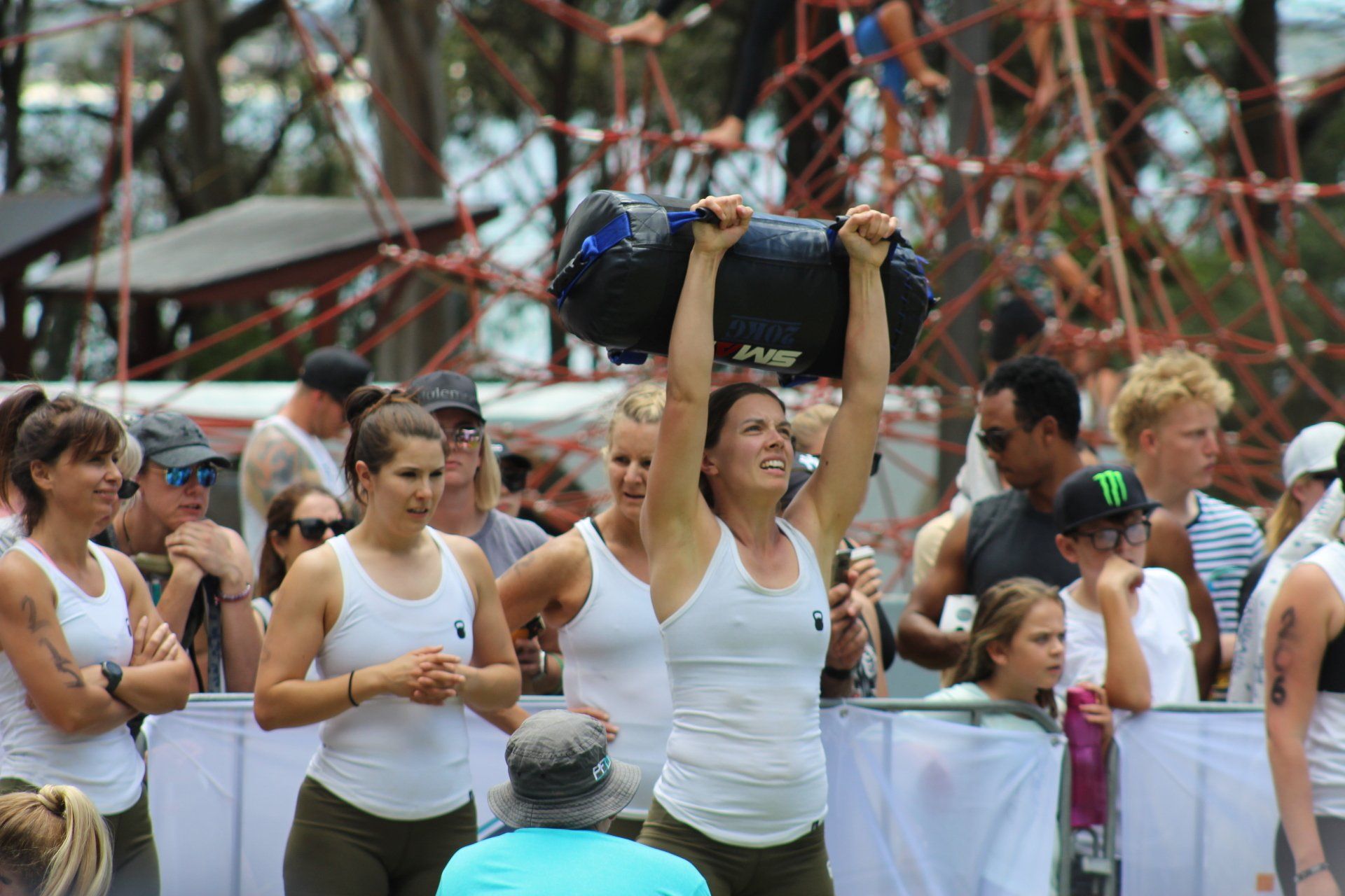 A woman is carrying a bag over her head in front of a crowd of people.