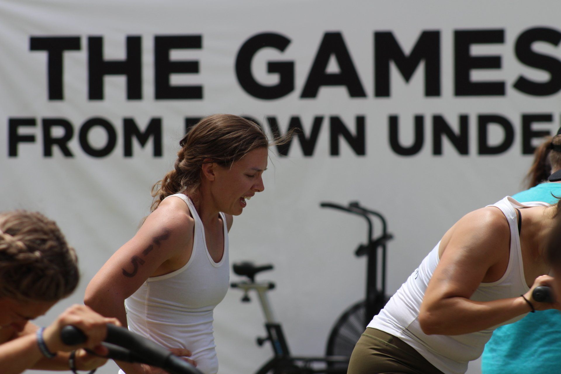 A group of people are working out in front of a sign that says the games from down under