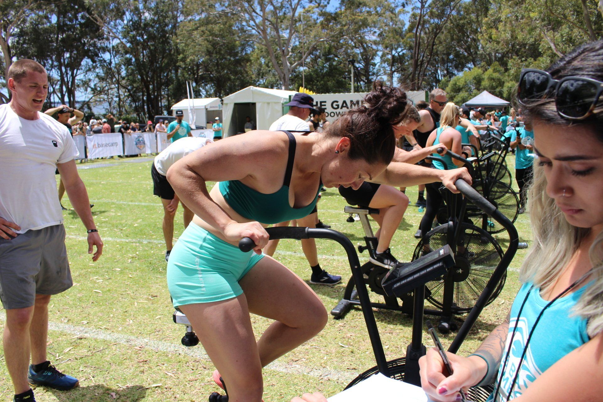 A group of people are riding exercise bikes on a field.