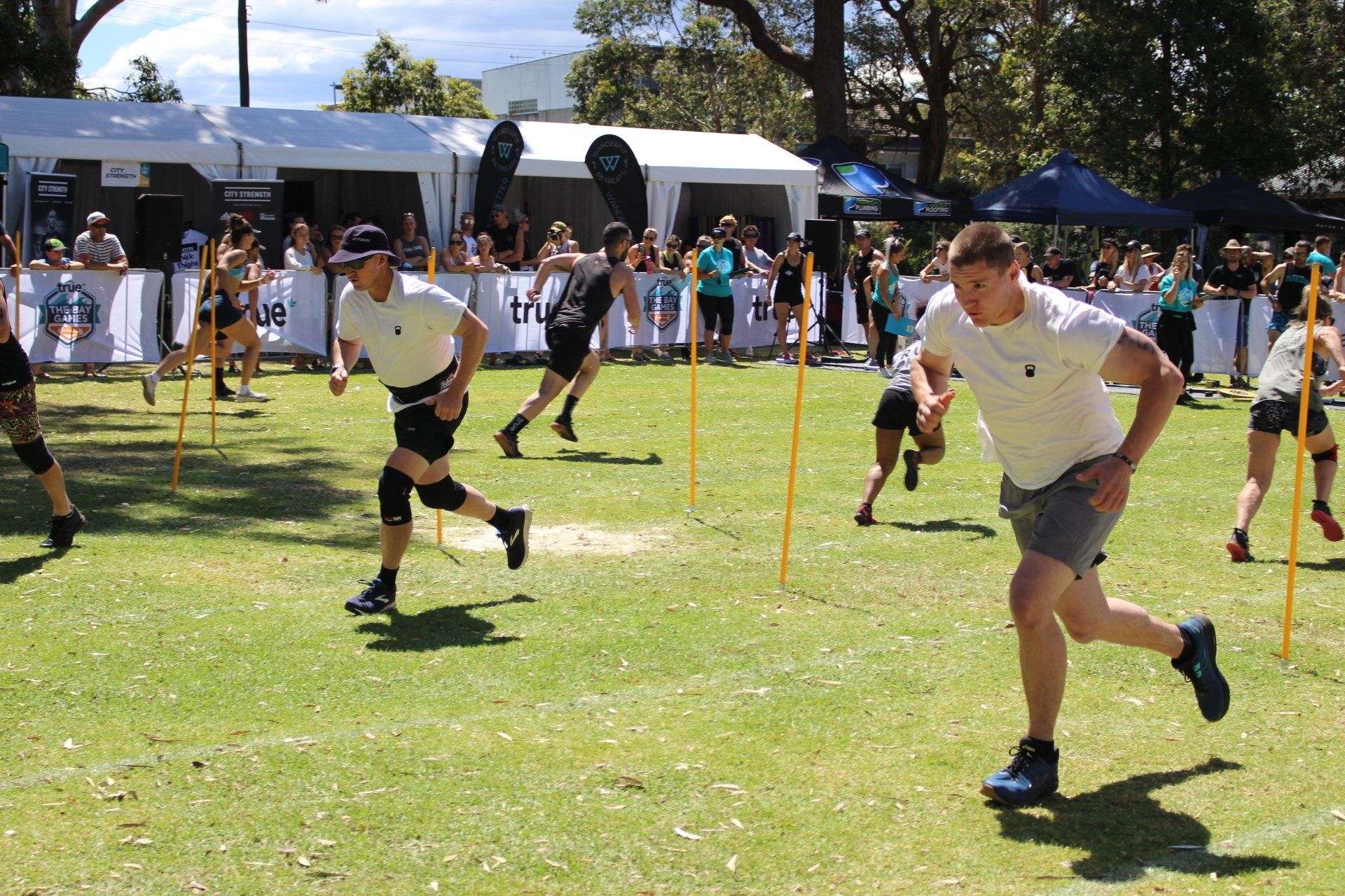 A group of people are running on a grassy field