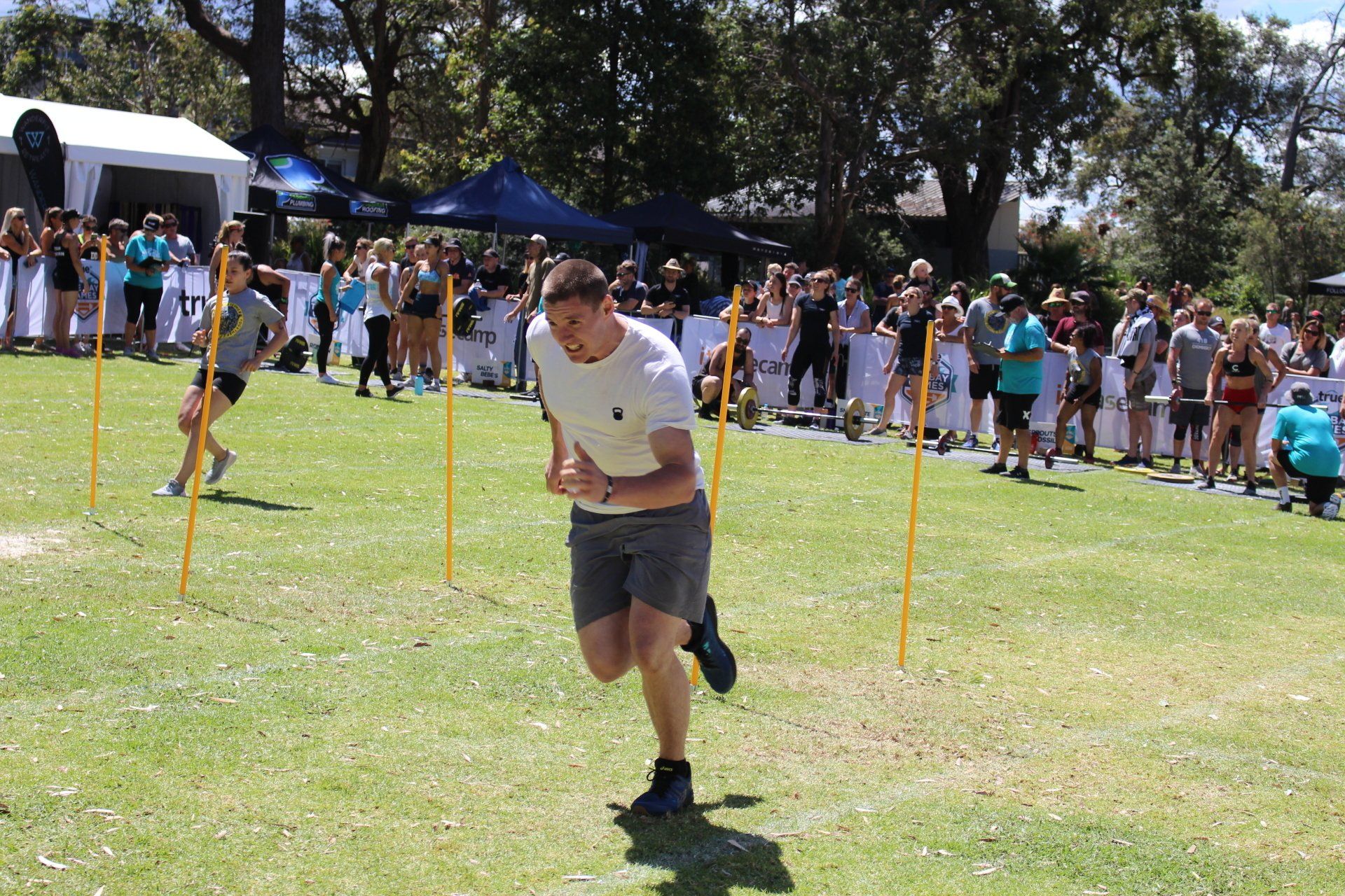 A man is running in a field with a crowd watching.