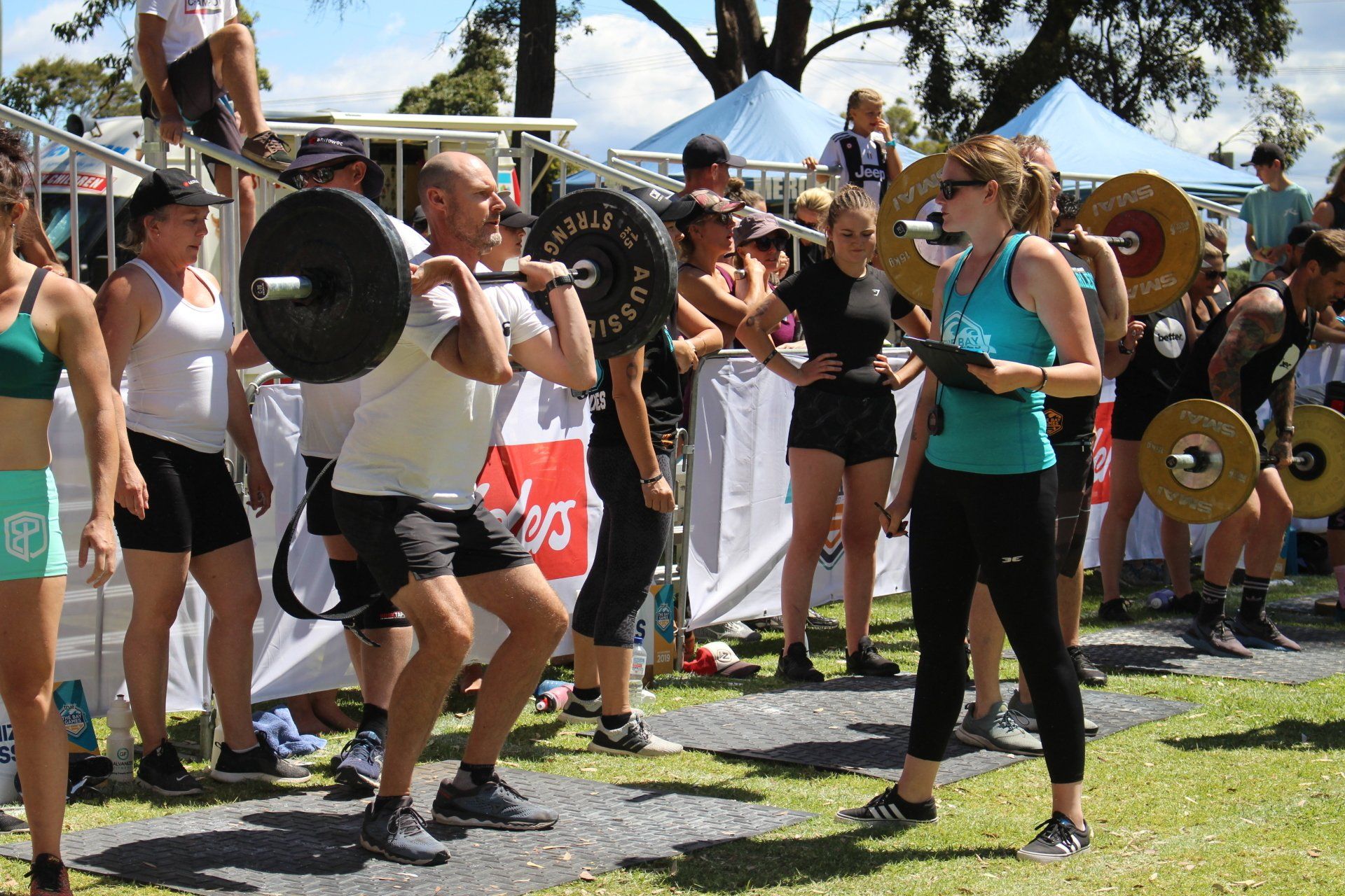A group of people are lifting weights in a park.