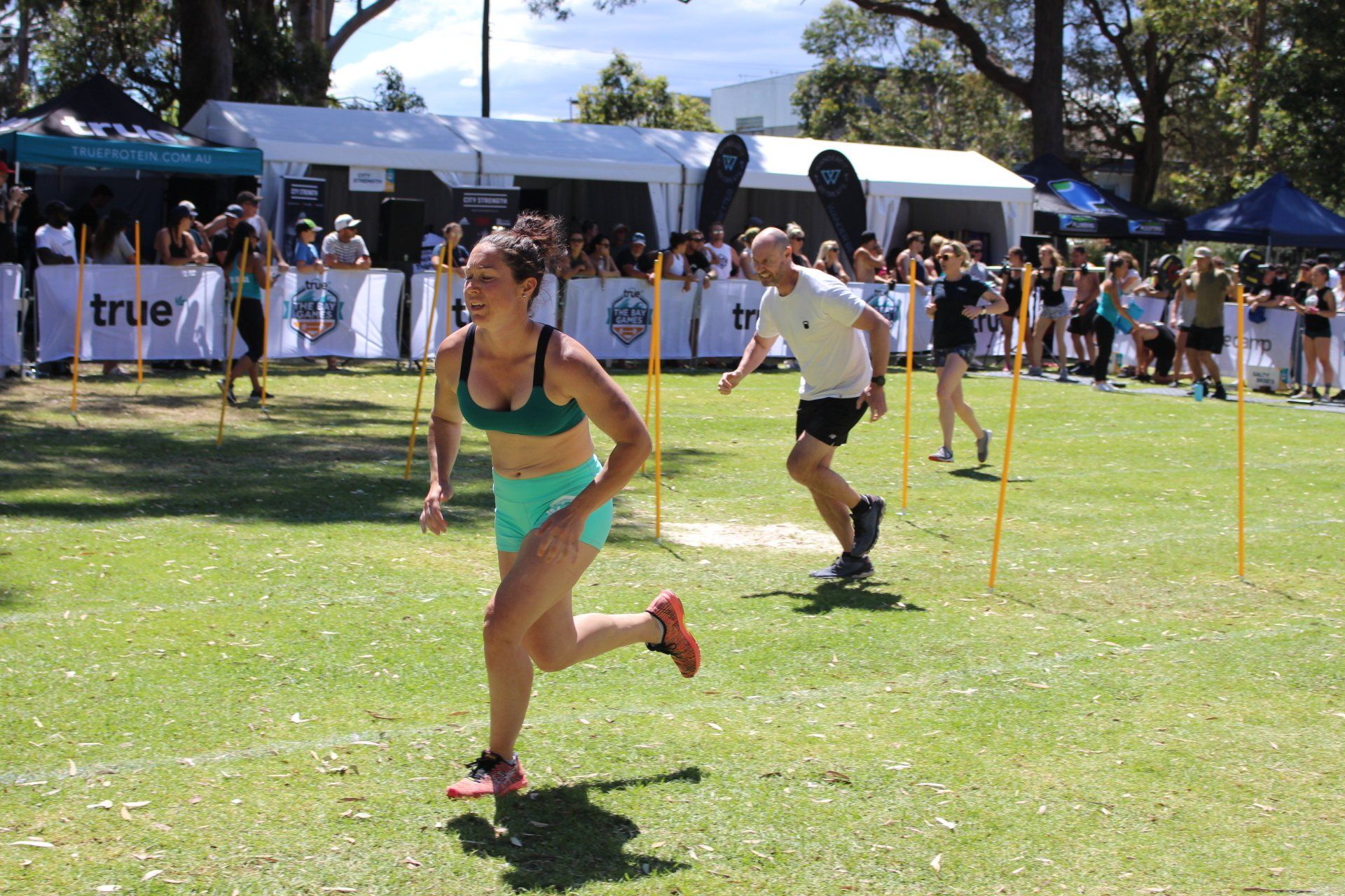 A woman in a green top is running in a field