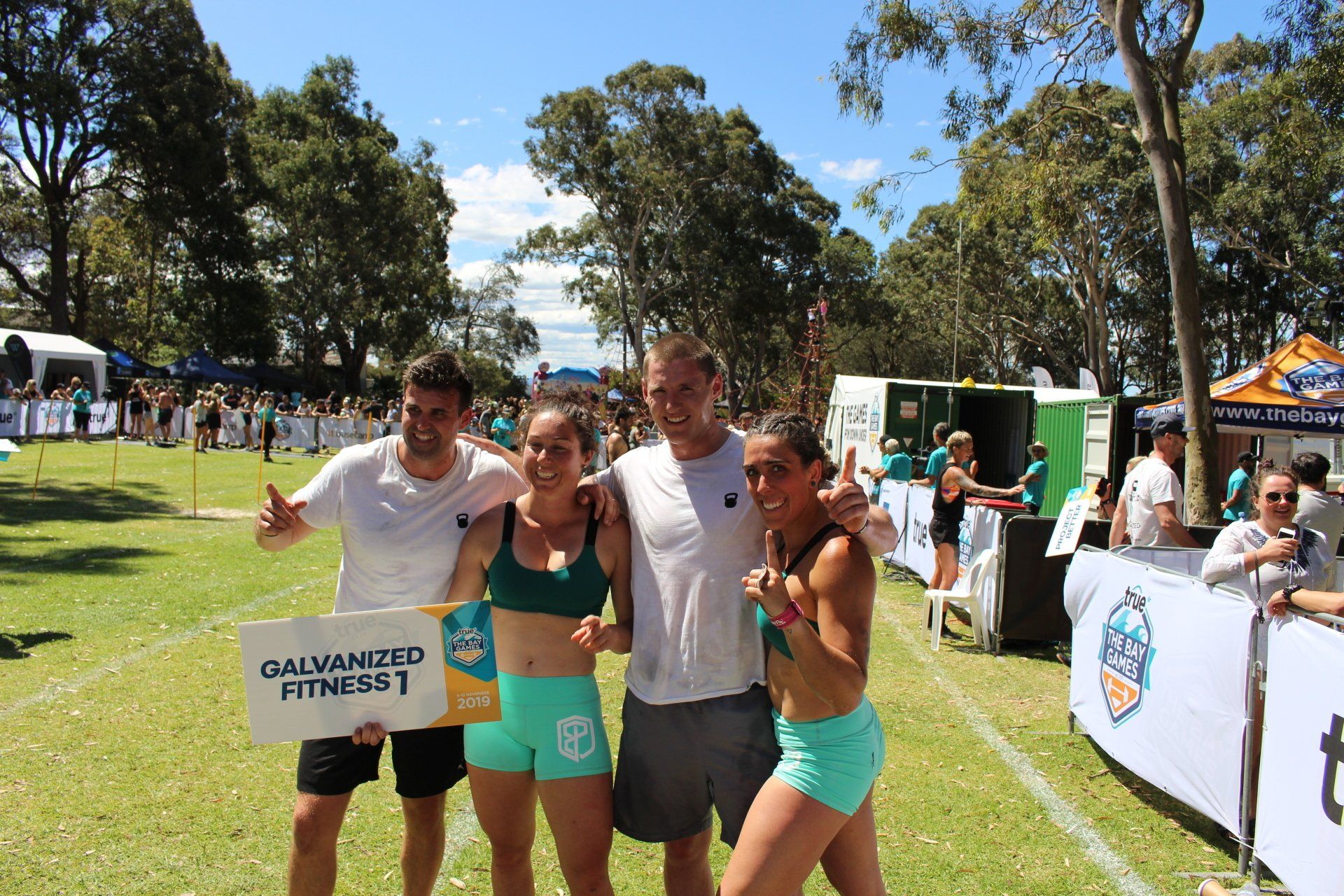 A group of people posing for a picture with a sign that says galvanized fitness