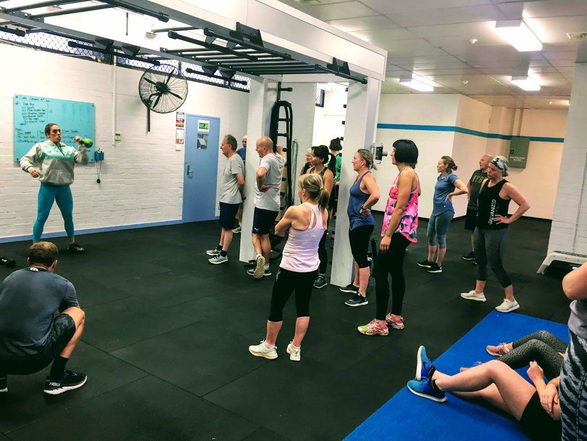 A group of people learning about the fitness session they are about to complete.