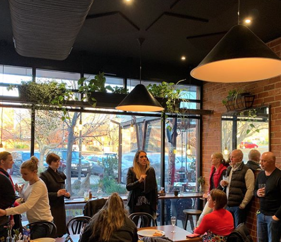 A group of people are sitting at tables in a restaurant