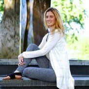 A woman is sitting on the steps of a building.