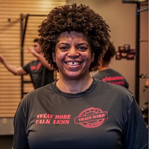 A woman wearing a shirt that says sweat more talk less