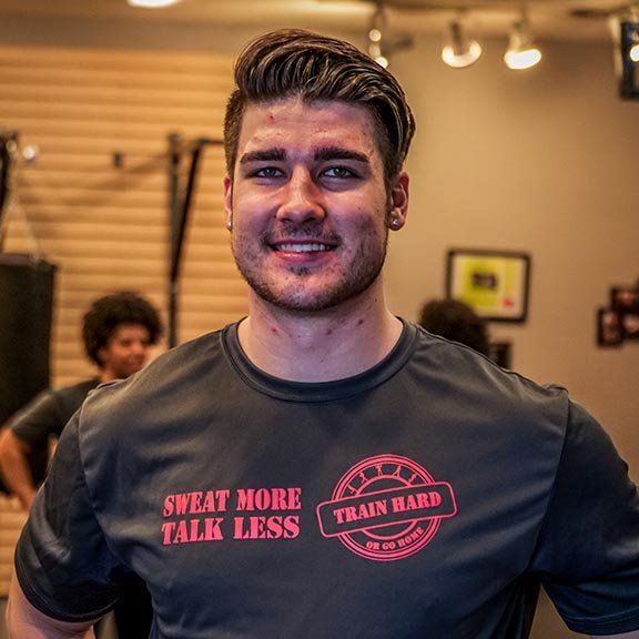A man wearing a shirt that says sweat more talk less
