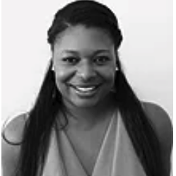 A woman with long hair is smiling in a black and white photo.