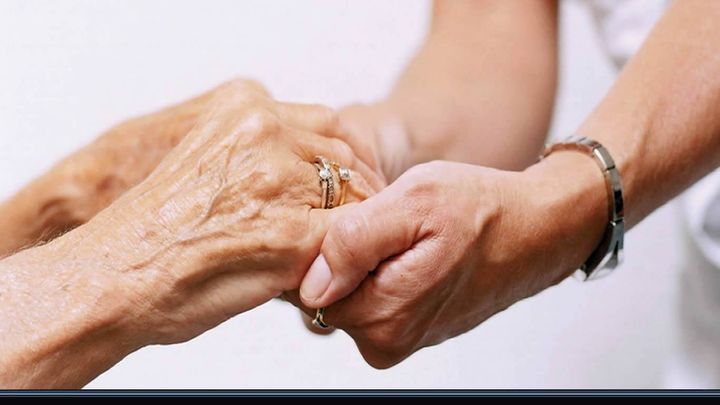 stretta di mano tra paziente anziano e infermiere
