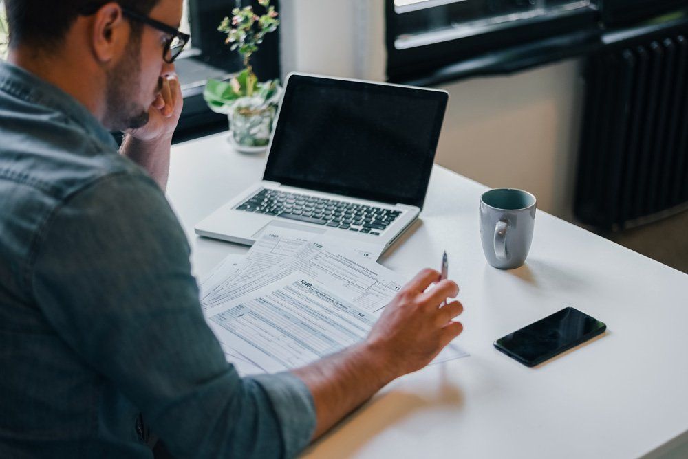 Man Filling Income Tax Return Papers — Dallas, TX — Dynamic Customize Tax