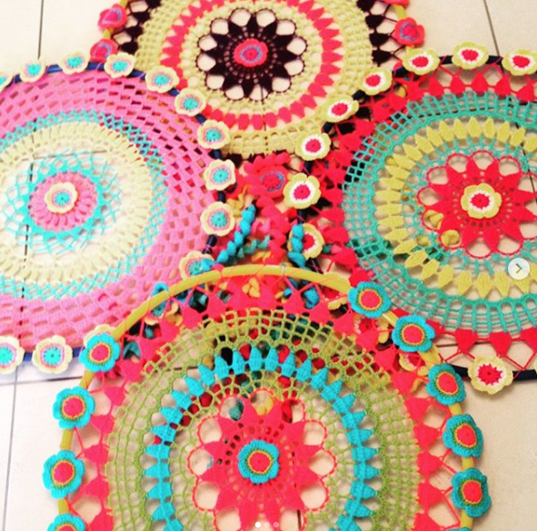 A bunch of colorful crocheted circles on a tile floor