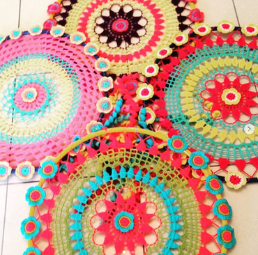 A bunch of colorful crocheted circles on a tile floor