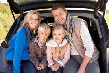 Happy Family at the Back of a Car — Insurance Services in Palm City, FL Happy Family at the Back of a Car — Insurance Services in Palm City, FL