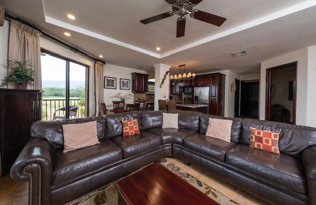 A living room filled with furniture and a ceiling fan.