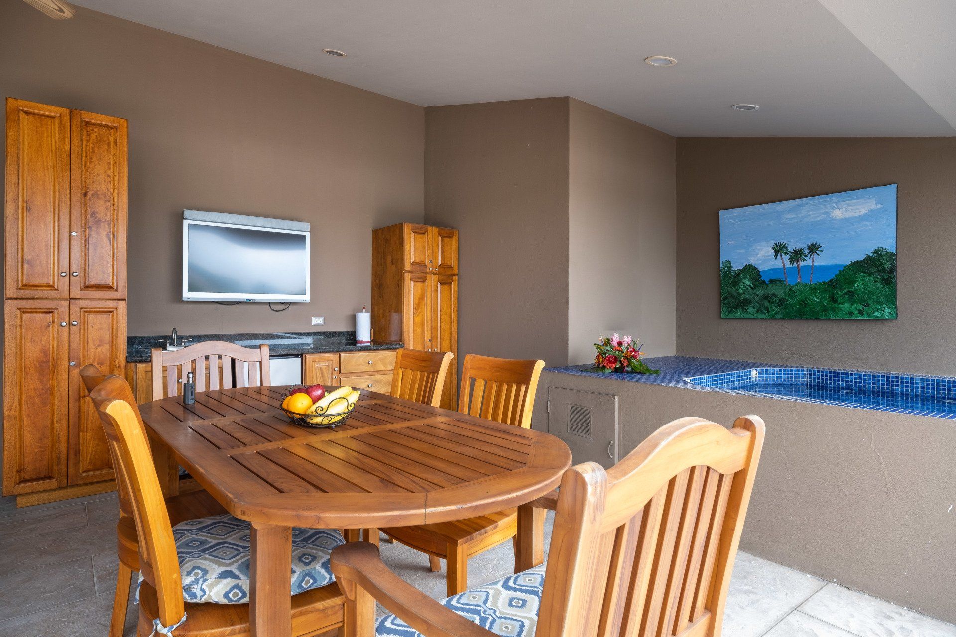 A dining room with a table and chairs and a television