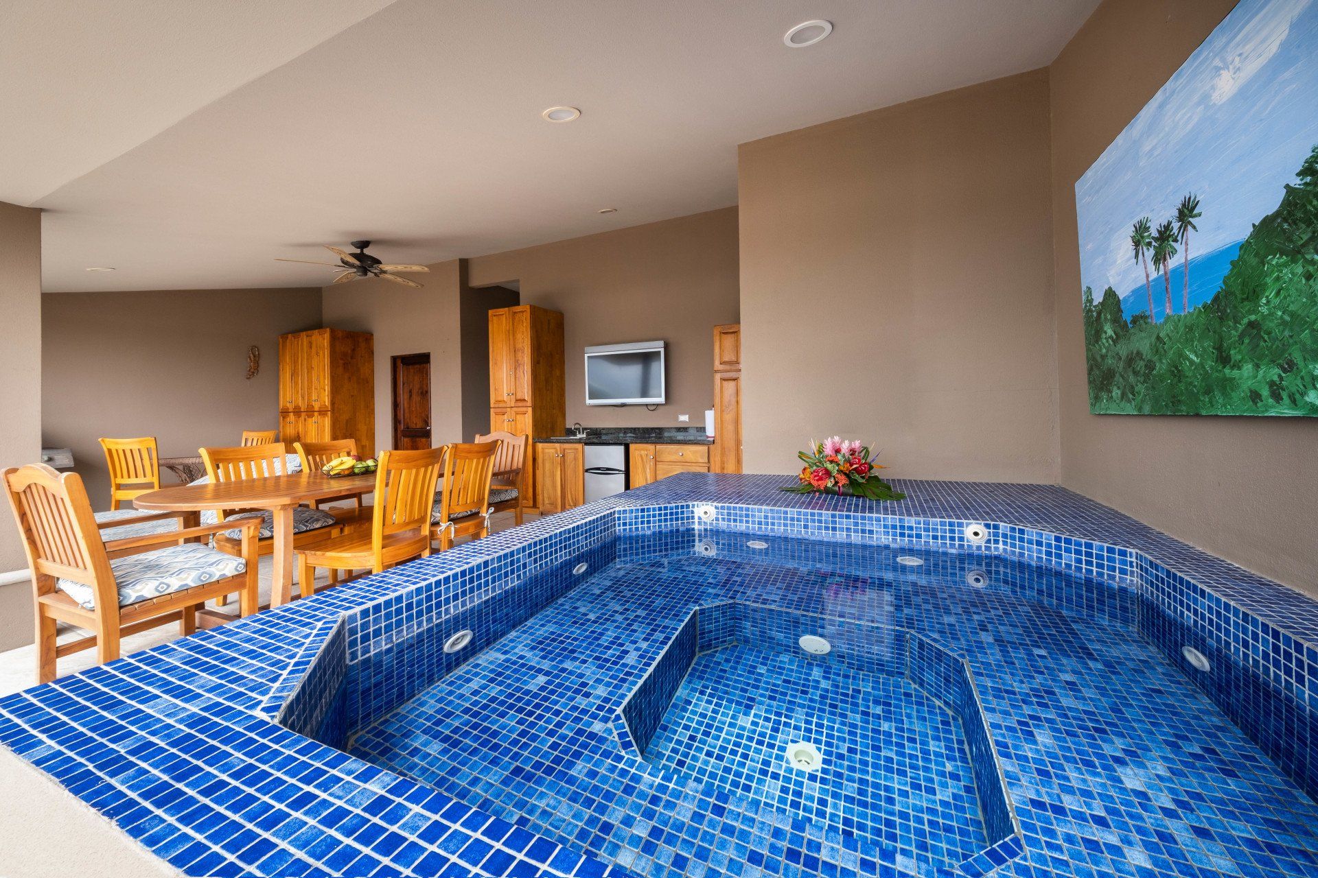 A jacuzzi in a living room with a painting on the wall above it