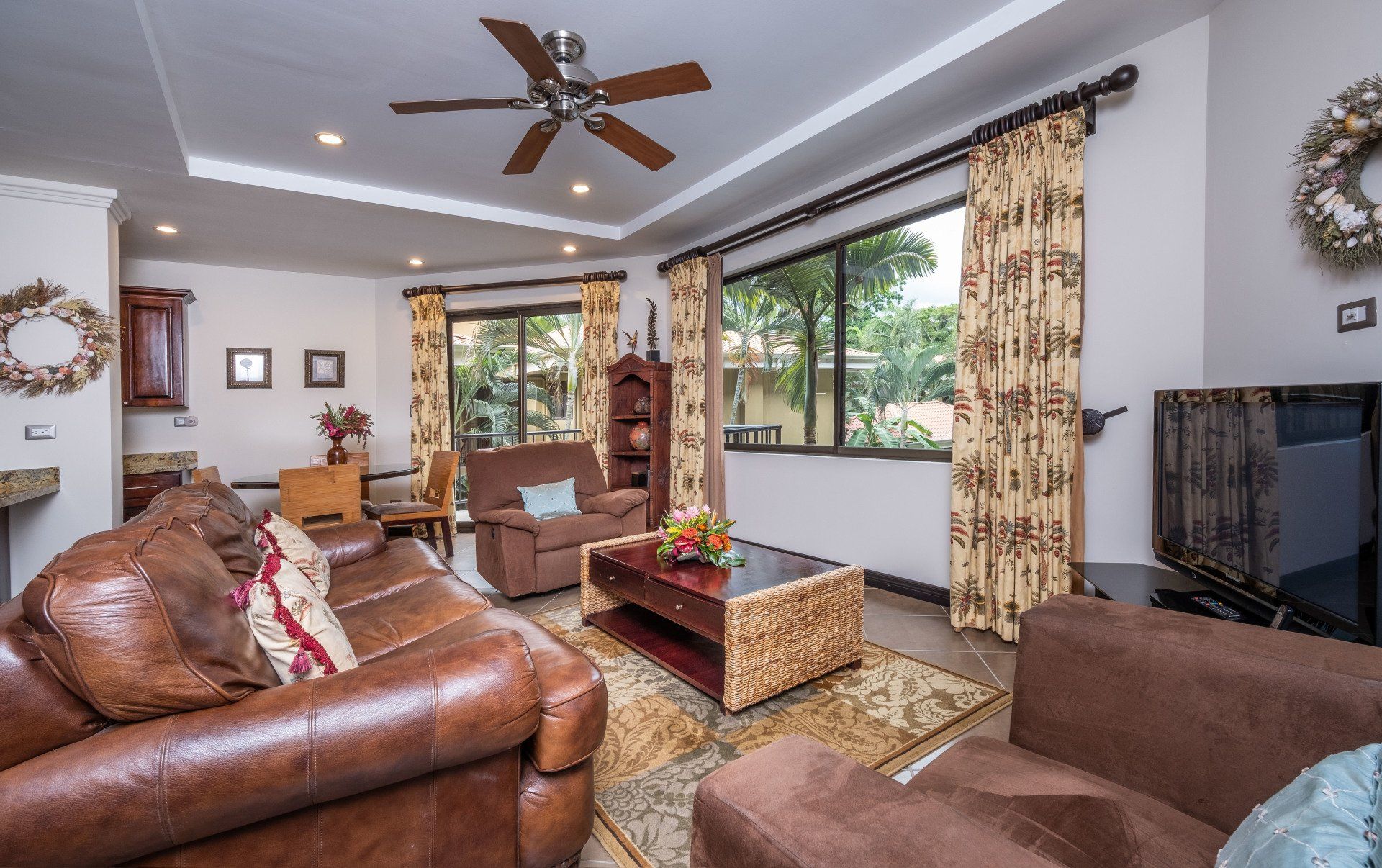 A living room filled with furniture and a ceiling fan.