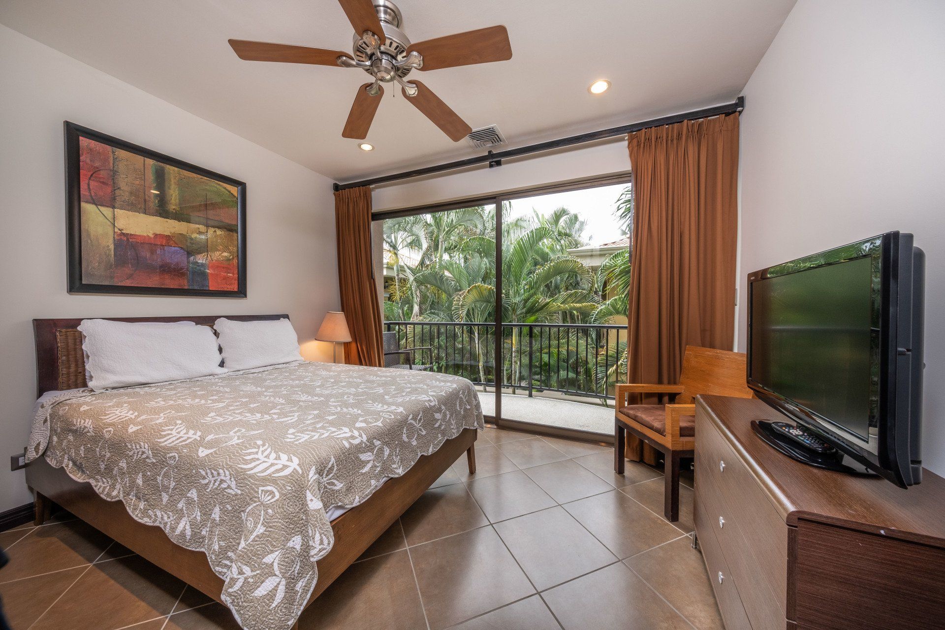 A bedroom with a large bed and a flat screen tv