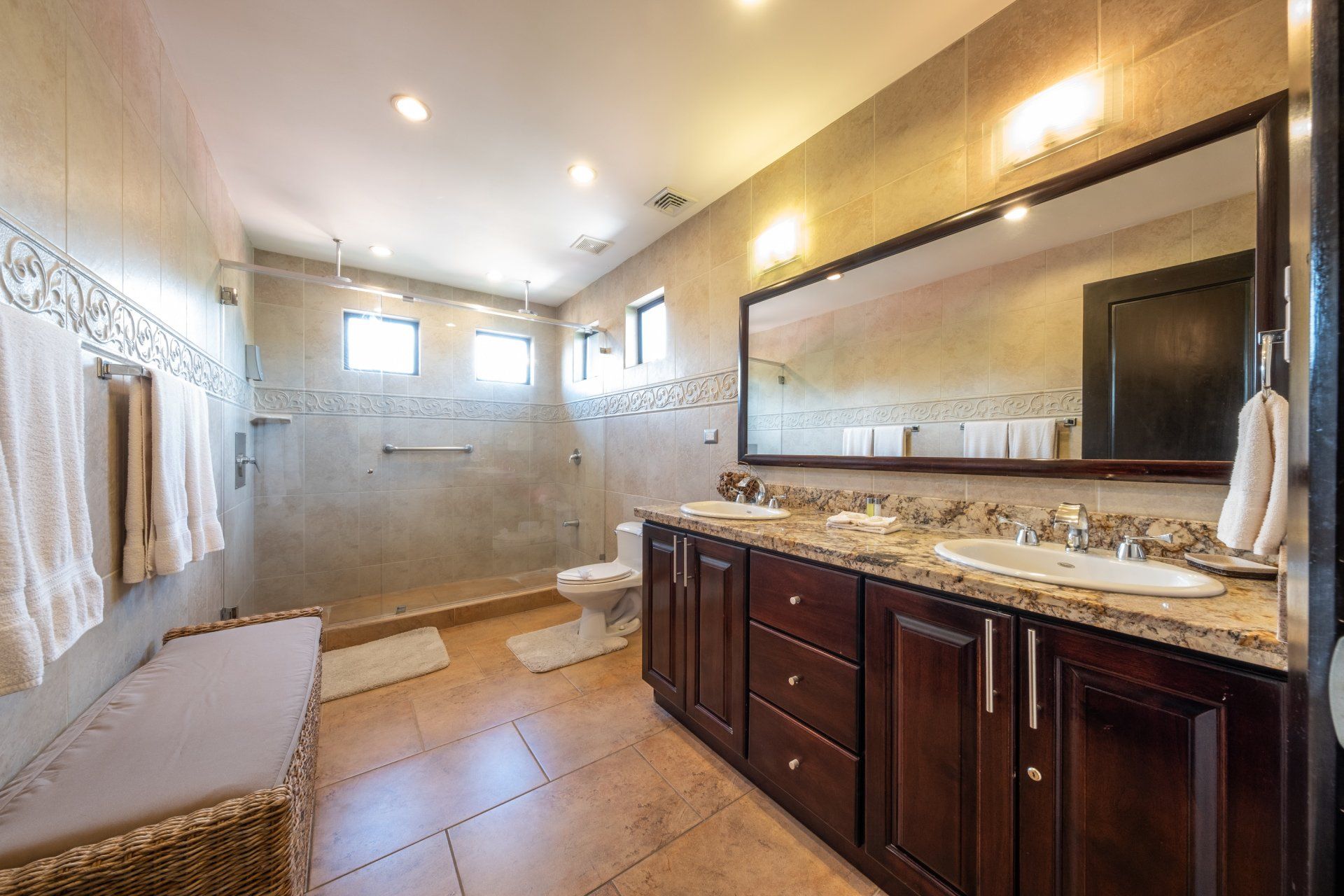 A bathroom with two sinks , a toilet , and a large mirror.