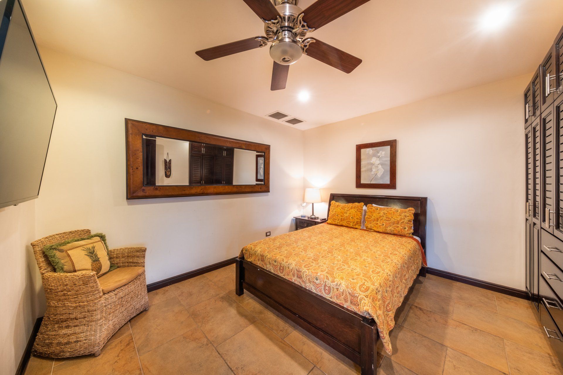 A bedroom with a bed , chair and ceiling fan