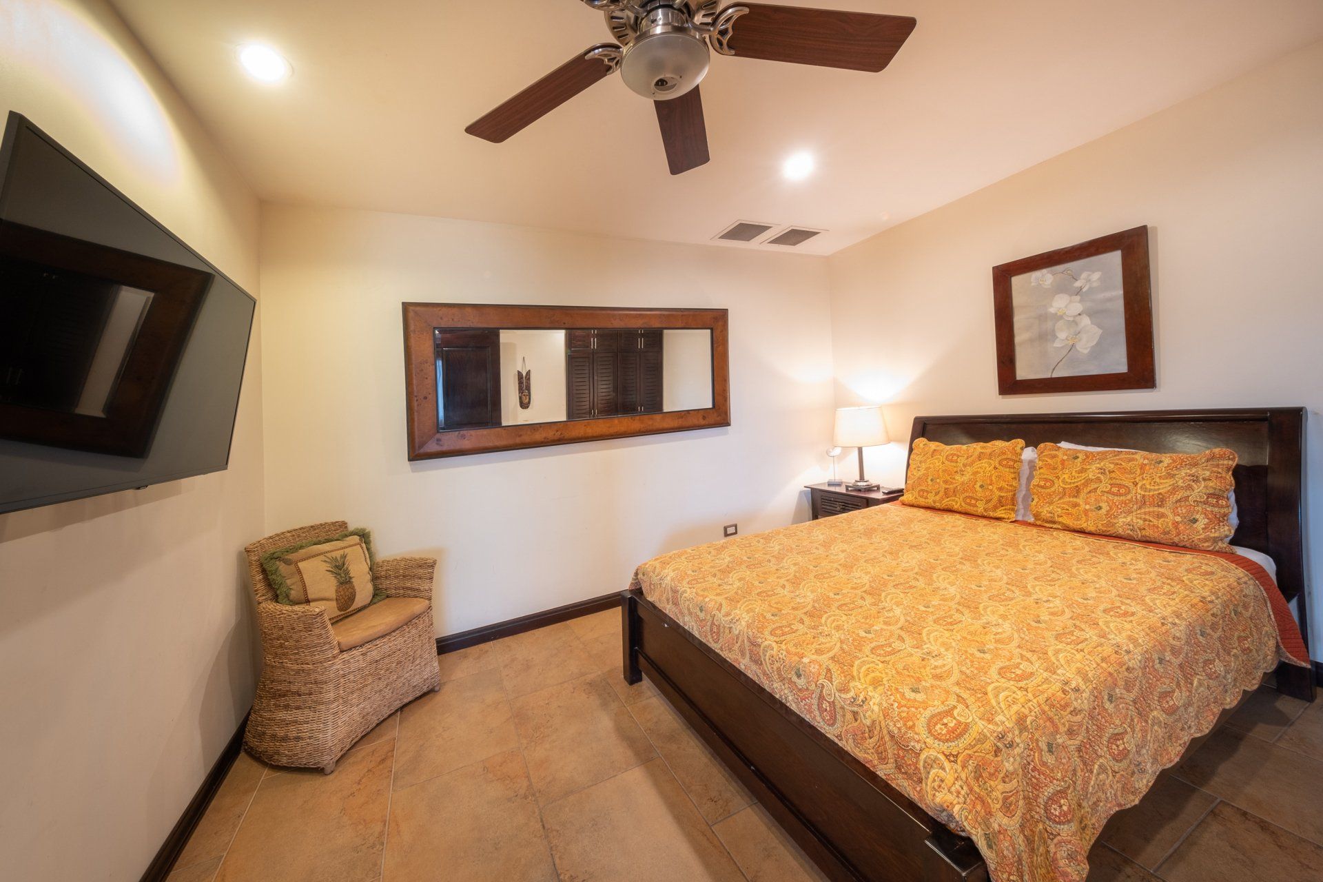 A bedroom with a king size bed and a ceiling fan