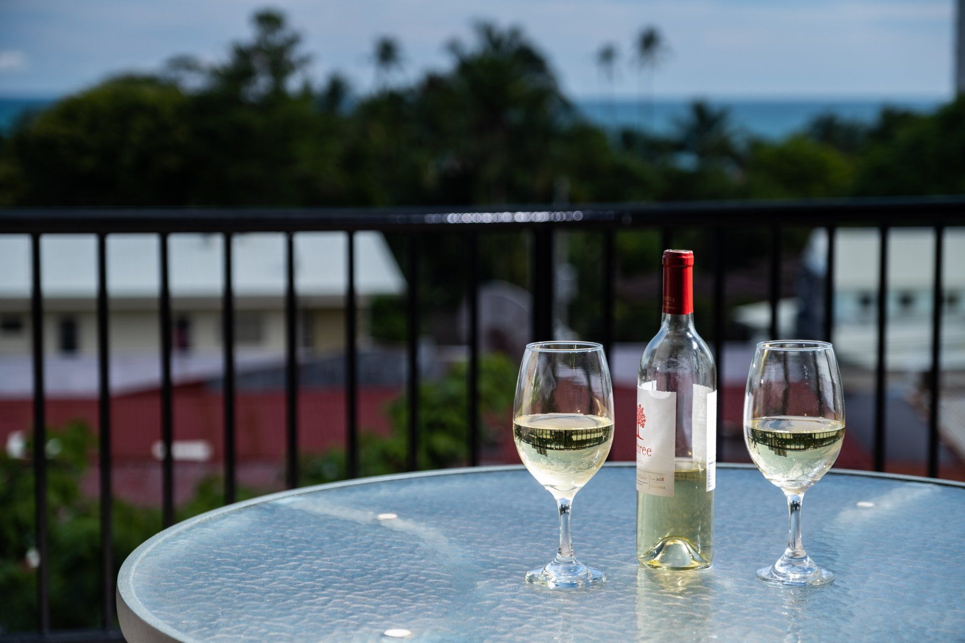 Two glasses of wine and a bottle of wine on a table.