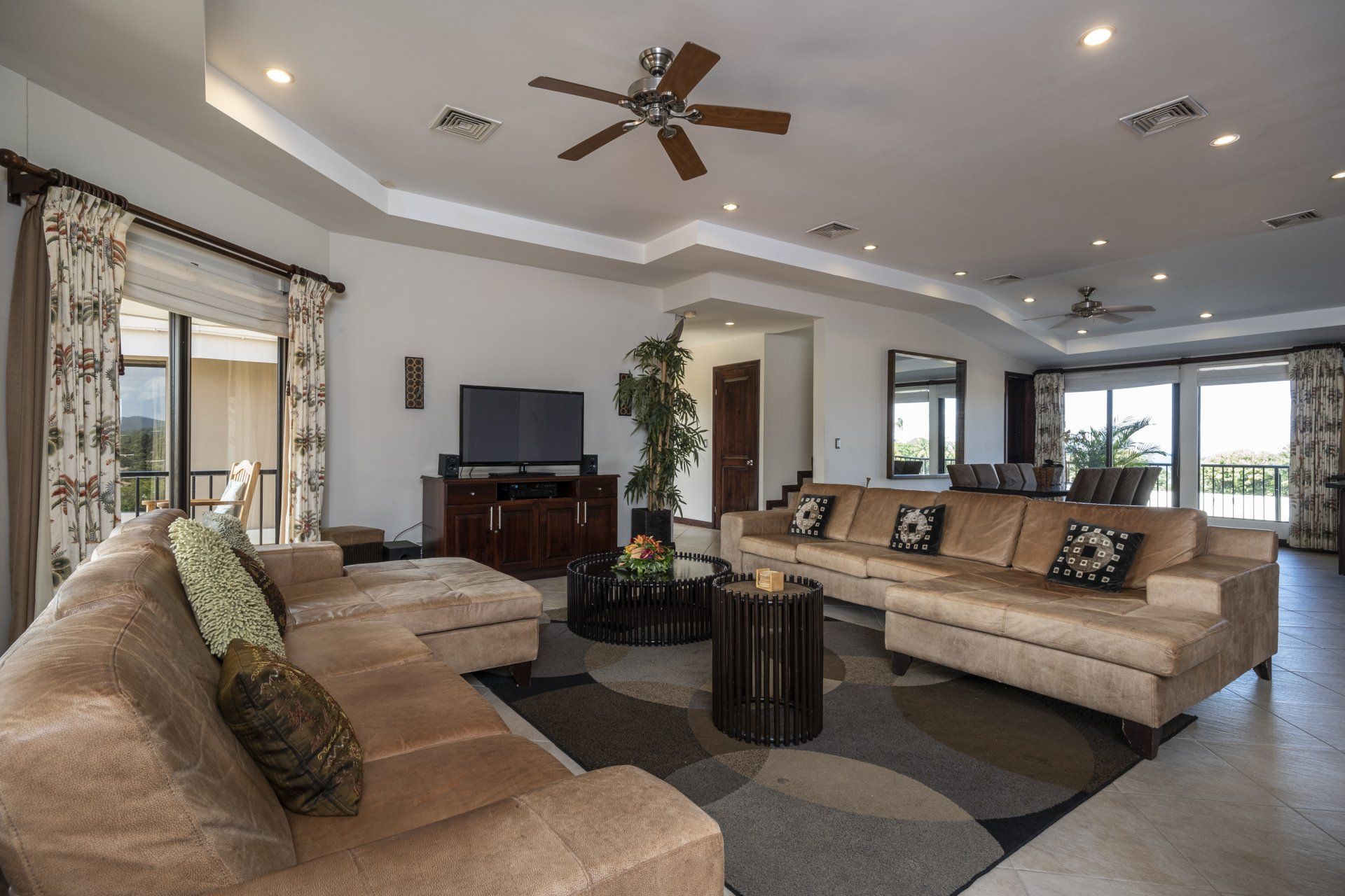 A living room with a lot of furniture and a ceiling fan
