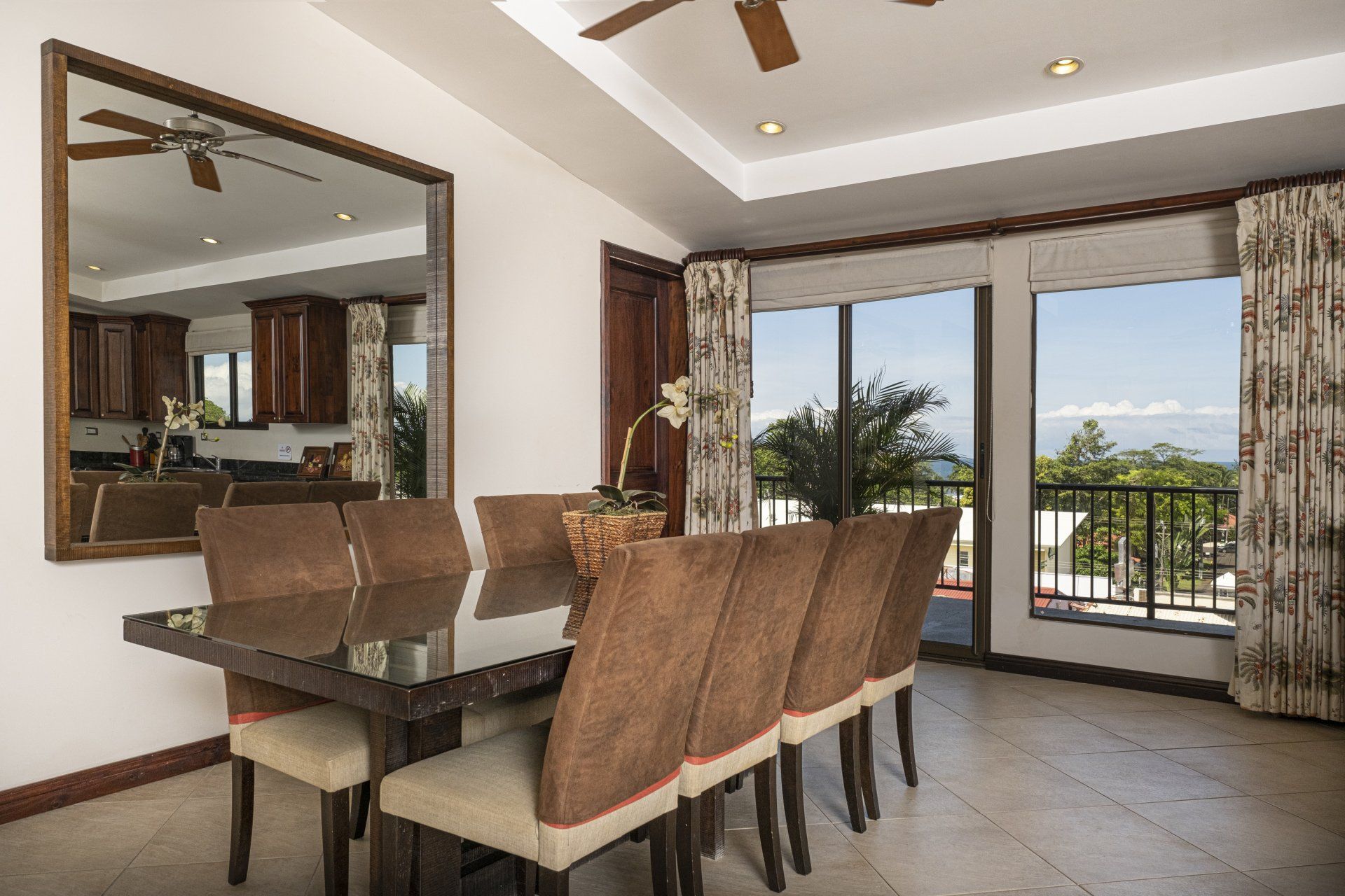 A dining room with a table and chairs and a large mirror