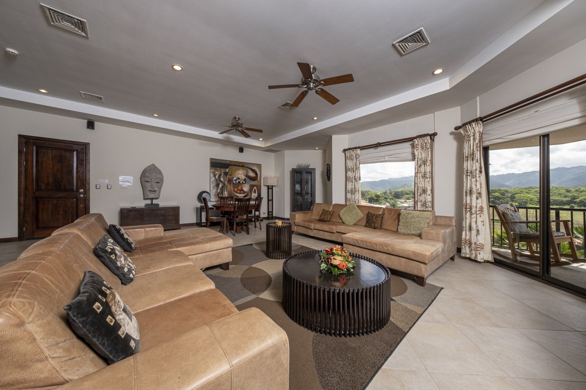 A living room with a lot of furniture and a ceiling fan
