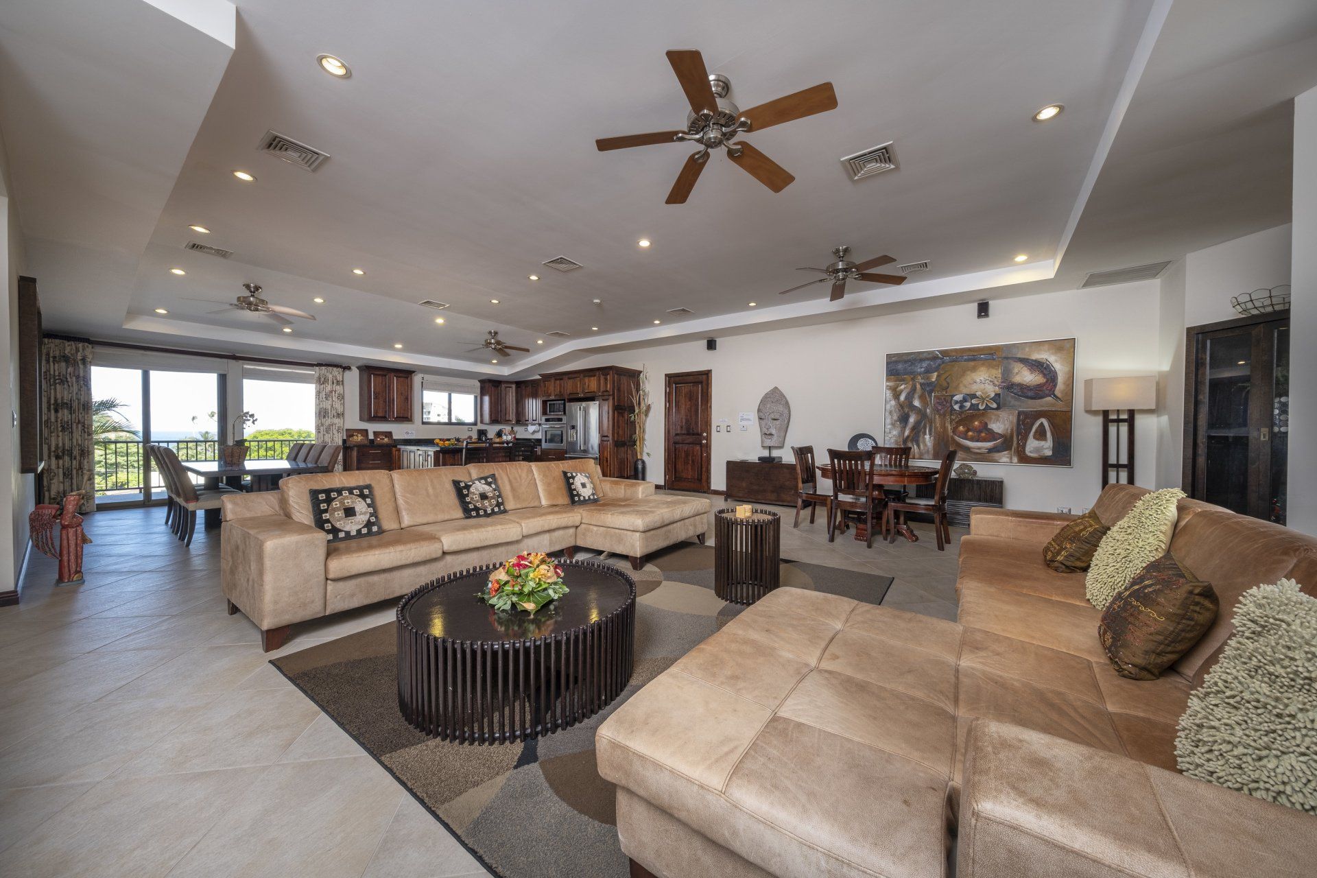 A living room with a lot of furniture and a ceiling fan