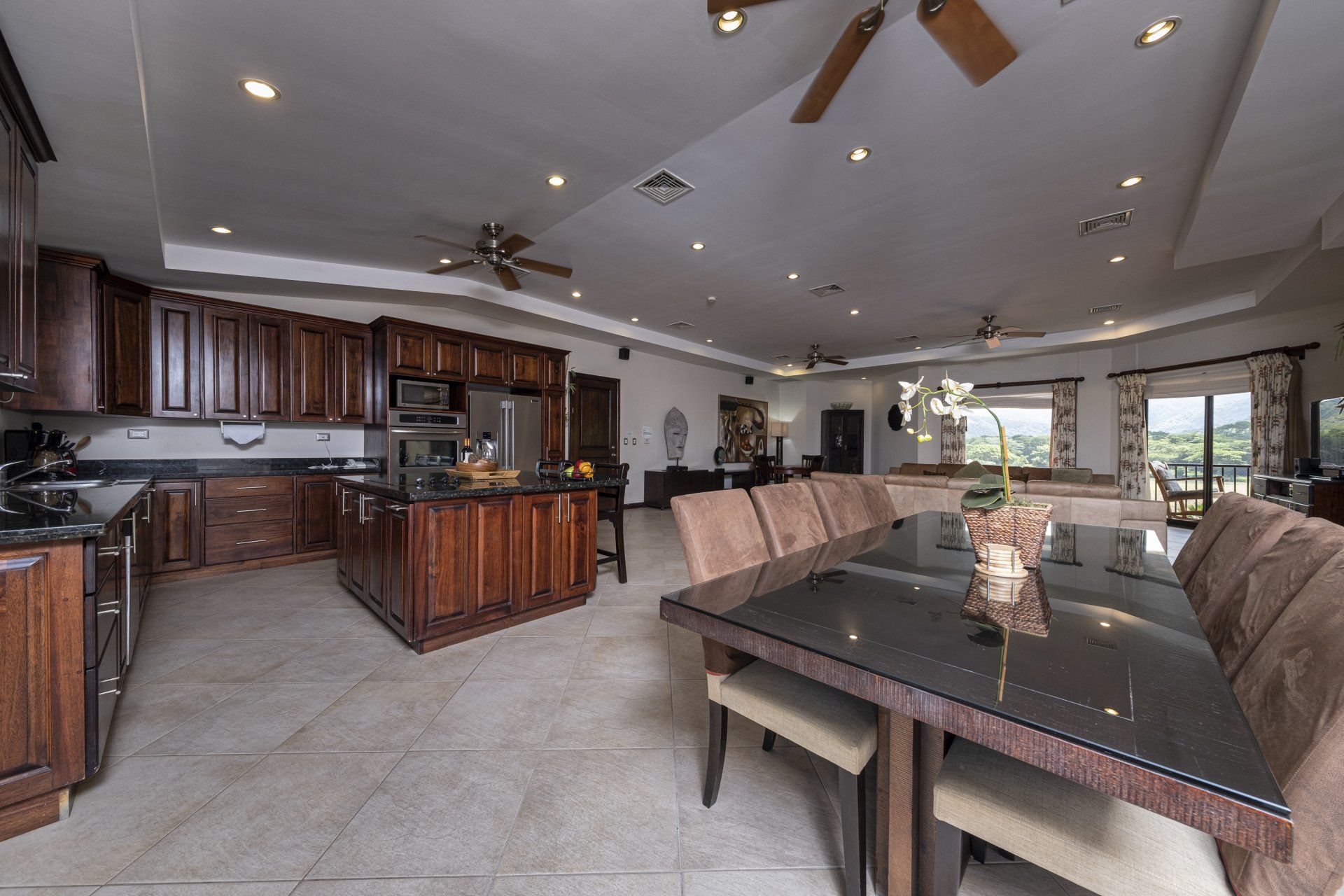 A kitchen with a dining table and chairs and a ceiling fan