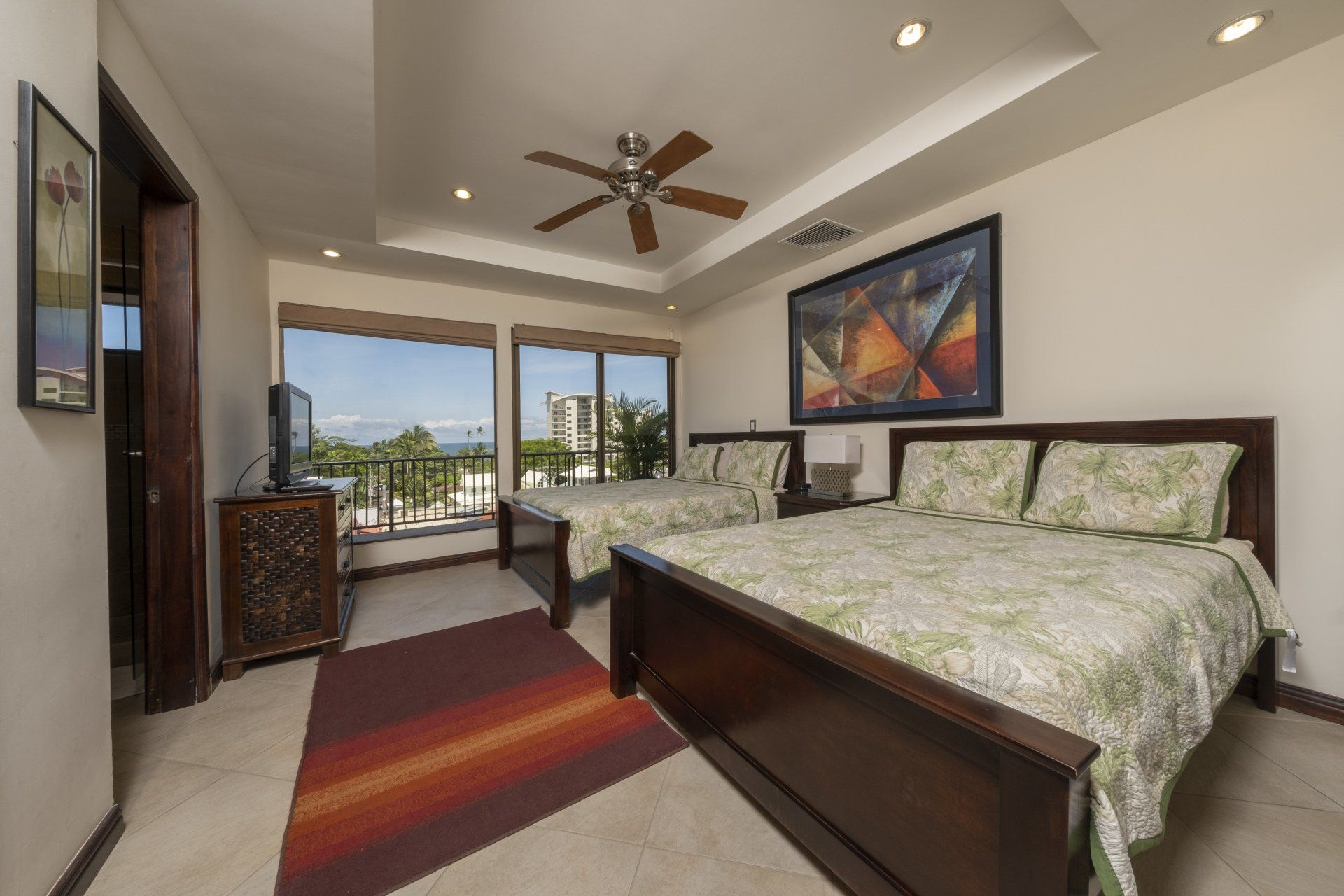 A bedroom with two beds and a ceiling fan