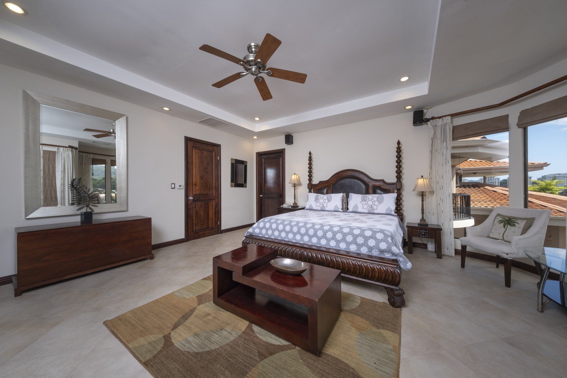 A bedroom with a large bed and a ceiling fan