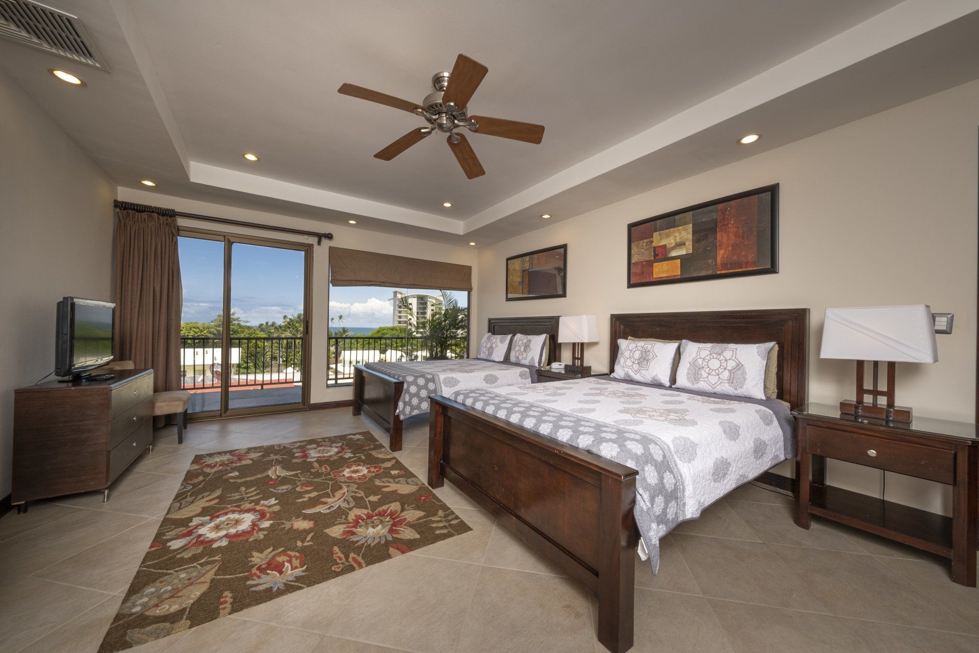 A bedroom with two beds and a ceiling fan