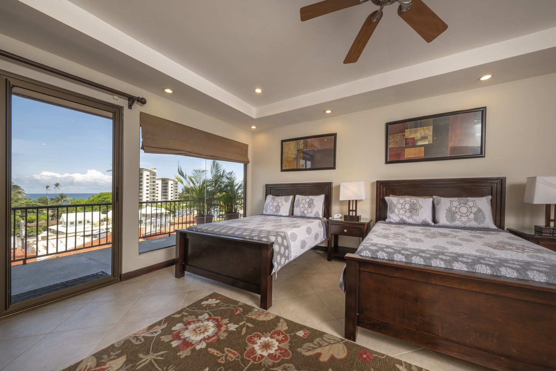 A bedroom with two beds and a ceiling fan