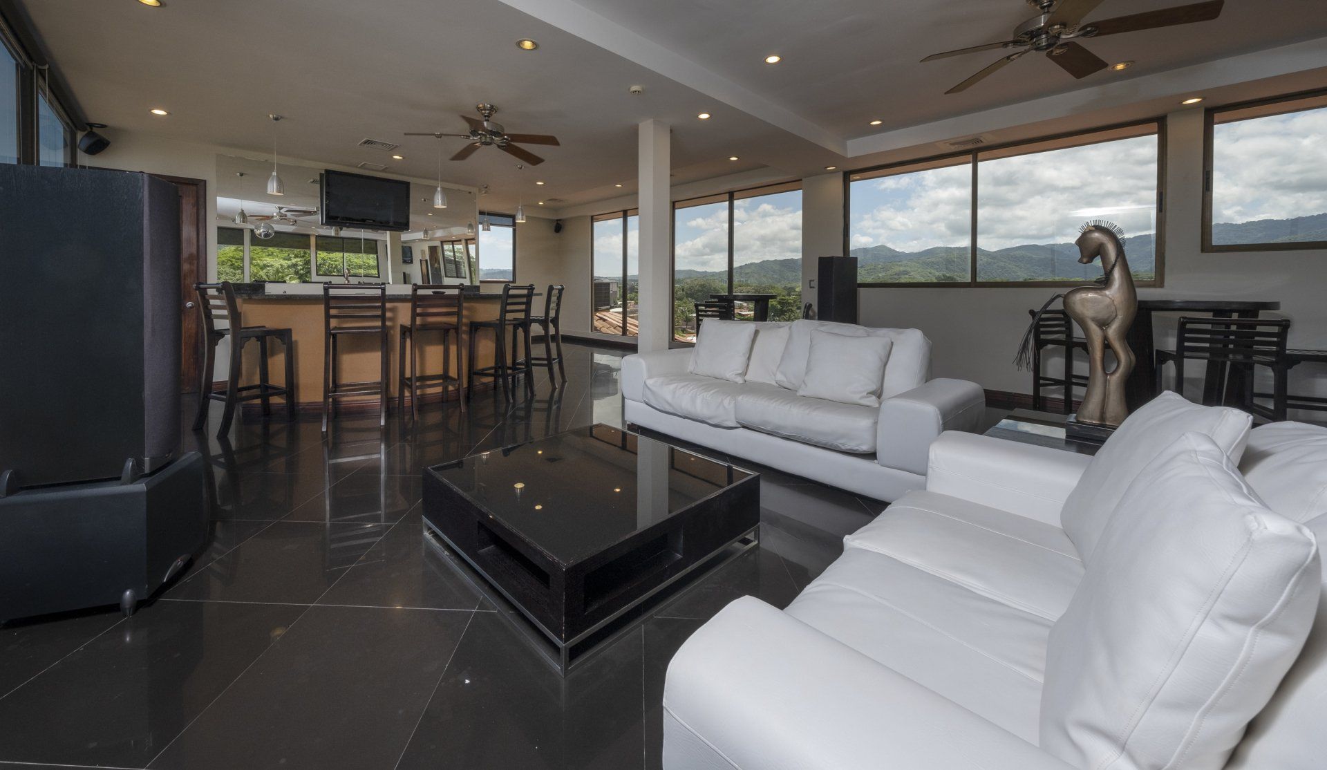 A living room with white furniture and a black table