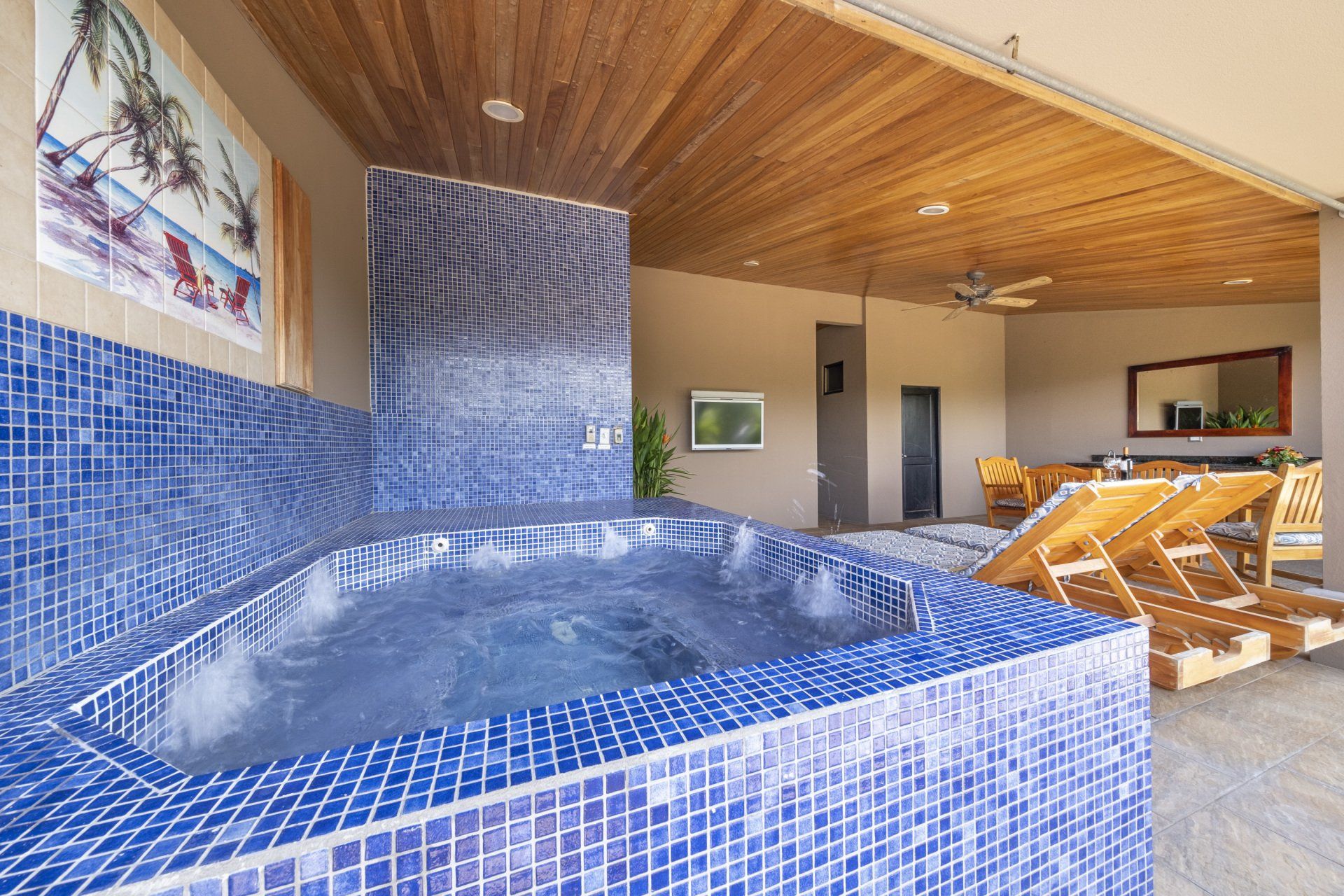 A hot tub with blue tiles surrounding it in a room