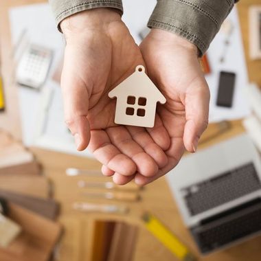 hands holding house