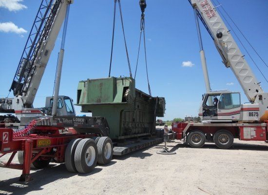 Two cranes loading equipment on heavy haul carrier in Laredo, TX