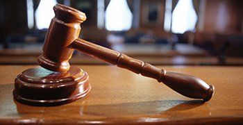 Wooden gavel on a wooden desk in a courtroom.