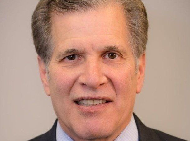 A man in a suit and tie is smiling for the camera.