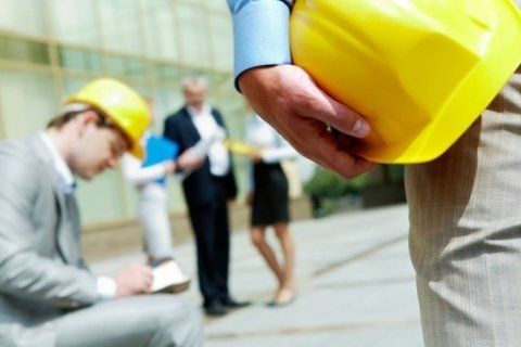 mano che tiene un caschetto giallo