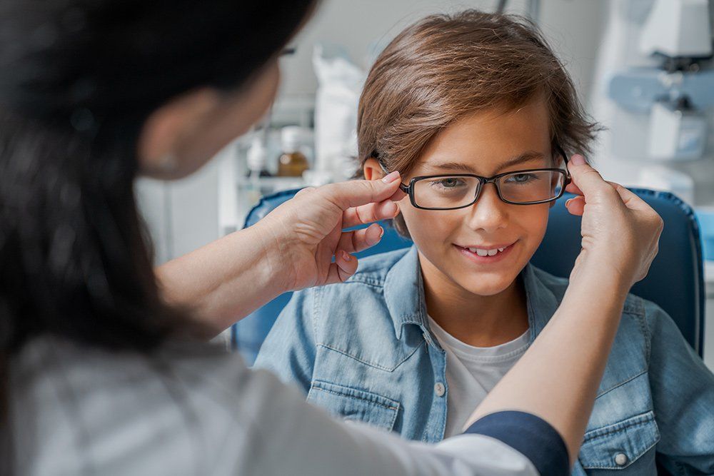 Putting Glasses on Little Boy — Chino, CA — Chino Optometry Center Putting Glasses on Little Boy — Chino, CA — Chino Optometry Center